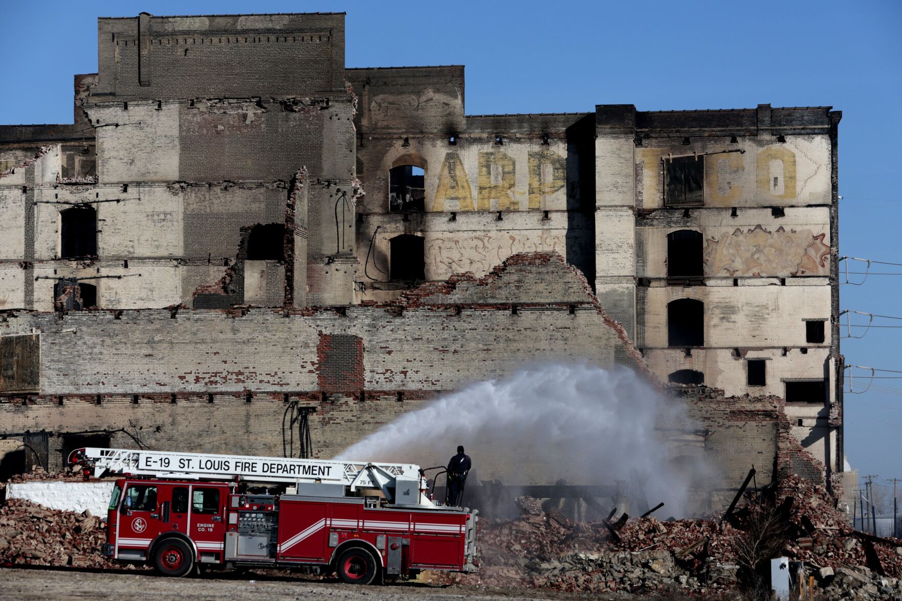 Fire Department still putting water on hot spots from massive warehouse Saturday
